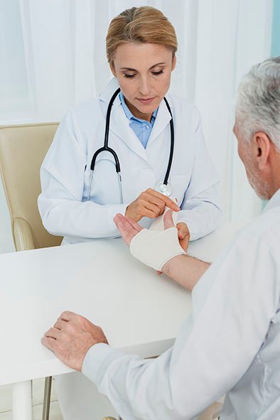 high-angle-doctor-bandaging-patient-hand